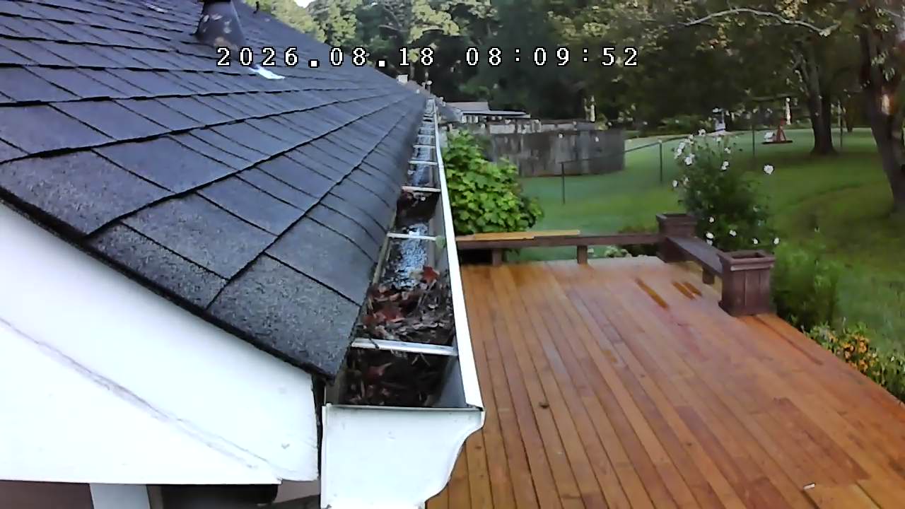 Gutter packed with wet leaves and debris before cleaning in Cumming, Georgia